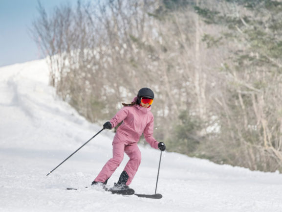 Ragazza sugli sci con tuta rosa